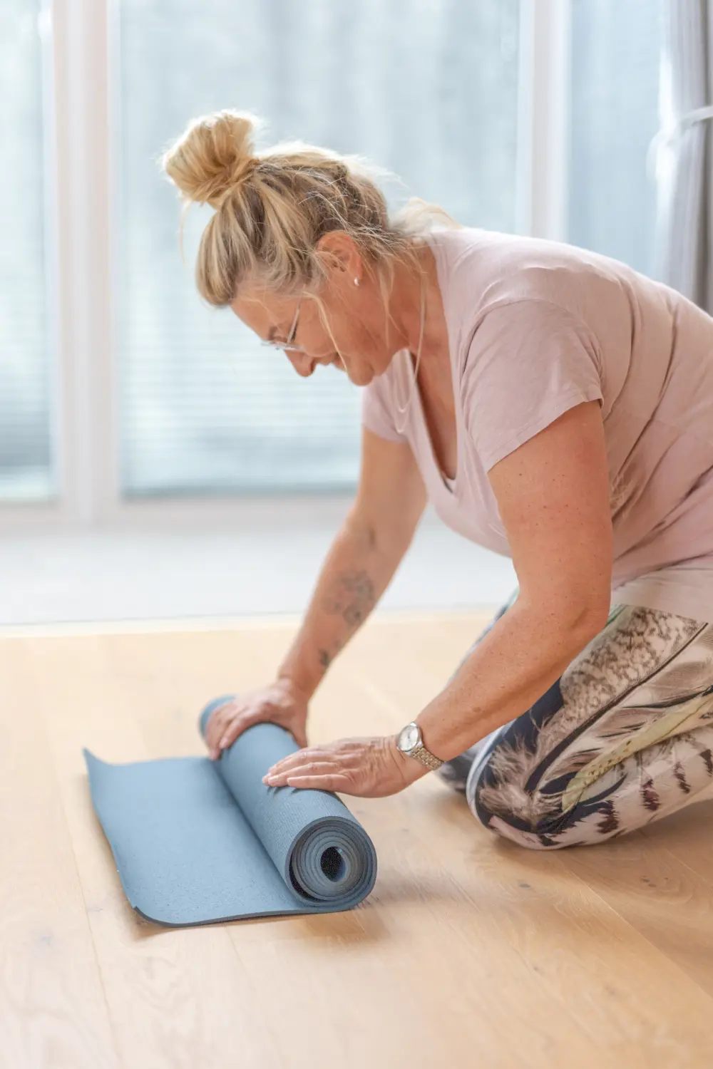 Anke Albrecht – Coach – Frau faltet Yogamatte